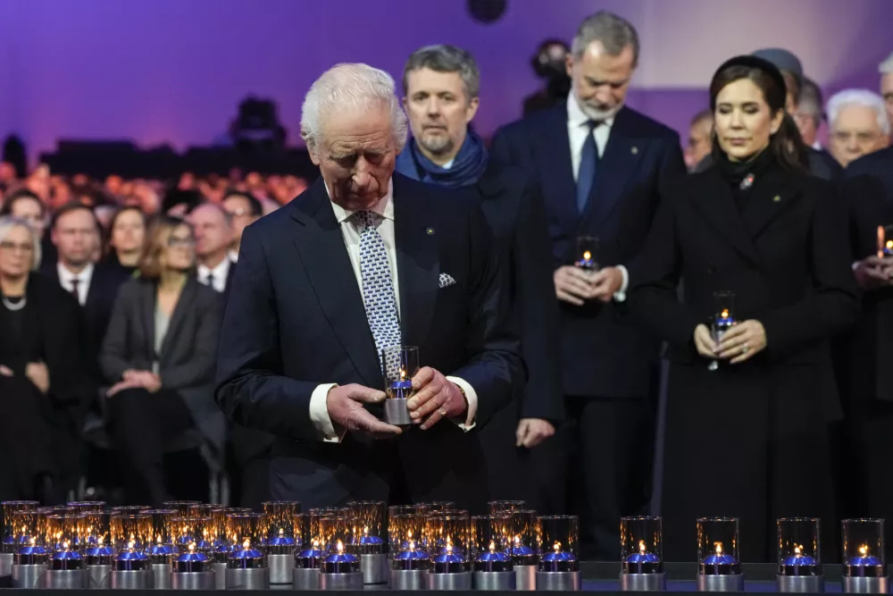 Britain's King Charles III places a lit candle at the Auschwitz-Birkenau former Nazi German concentration and extermination camp, during a ceremony marking the 80th anniversary of its liberation, in Oswiecim, Poland, Monday, Jan. 27. 2025. (AP Photo/Czarek Sokolowski)