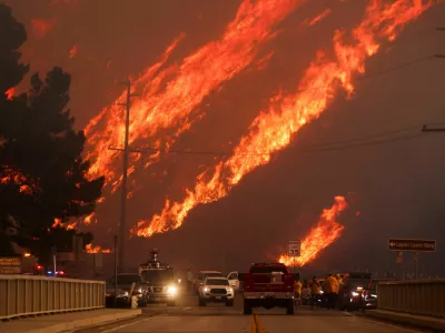 Flames rise behind vehicles as the Hughes Fire burns in Castaic Lake, California, U.S. January 22, 2025. REUTERS/David Swanson   TPX IMAGES OF THE DAY