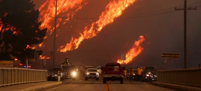 Flames rise behind vehicles as the Hughes Fire burns in Castaic Lake, California, U.S. January 22, 2025. REUTERS/David Swanson   TPX IMAGES OF THE DAY