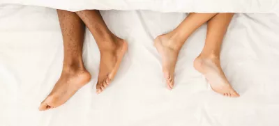 RWM90W African-american couple ignoring each other in bed