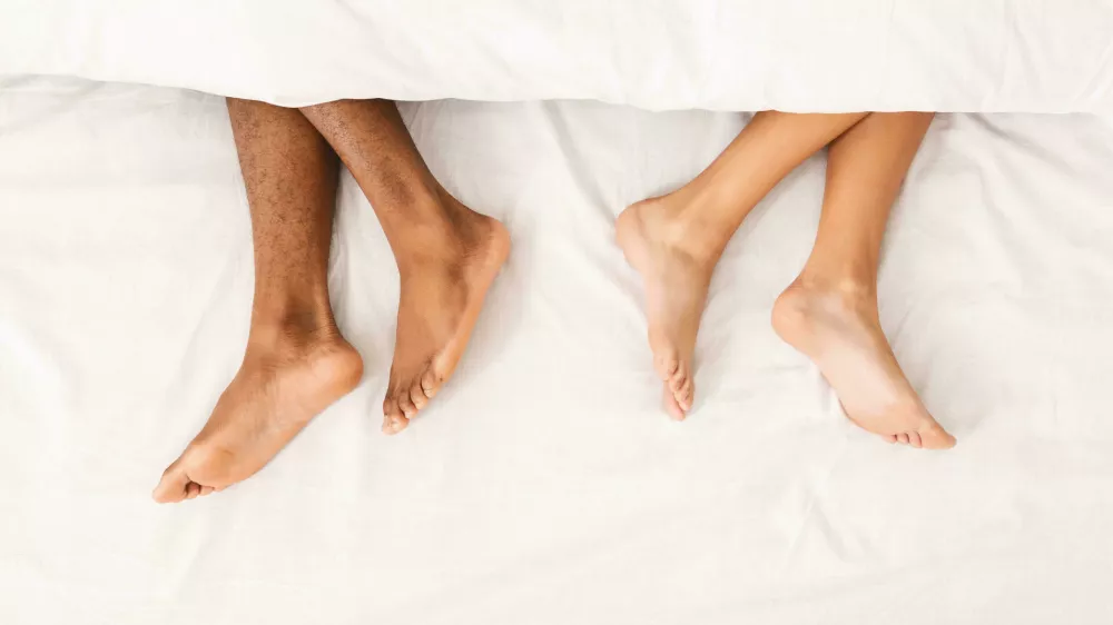 RWM90W African-american couple ignoring each other in bed