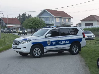 A police vehicle blocks the entrance to the village of Dubona, some 40 kilometers south of Belgrade, Serbia, Friday, May 5, 2023. A shooter killed multiple people and wounded more in a drive-by attack late Thursday in Serbia's second such mass killing in two days, state television reported. (AP Photo/Marko Drobnjakovic)