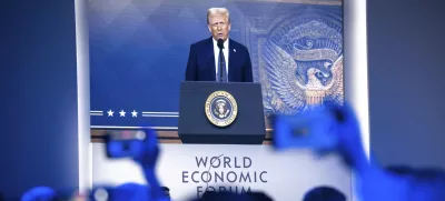 US President Donald J. Trump is shown on screens as he addresses via remote connection a plenary session in the Congress Hall, during the 55th annual meeting of the World Economic Forum (WEF), in Davos, Switzerland, Thursday, Jan. 23, 2025. (Laurent Gillieron/Keystone via AP)