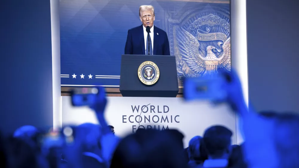 US President Donald J. Trump is shown on screens as he addresses via remote connection a plenary session in the Congress Hall, during the 55th annual meeting of the World Economic Forum (WEF), in Davos, Switzerland, Thursday, Jan. 23, 2025. (Laurent Gillieron/Keystone via AP)