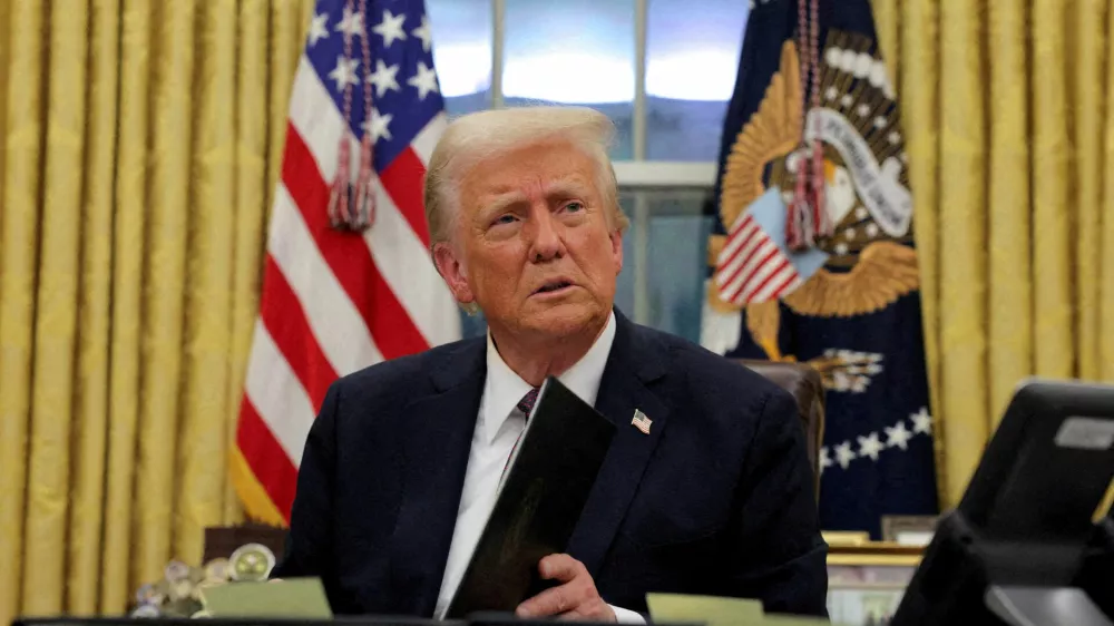 FILE PHOTO: U.S. President Donald Trump signs documents as he issues executive orders and pardons in the Oval Office at the White House on Inauguration Day in Washington, U.S., January 20, 2025. REUTERS/Carlos Barria/File Photo