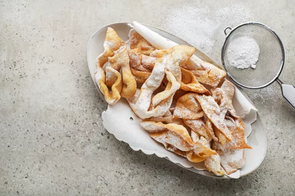 Traditional sweet crisp pastry - faworki or angel wings, deep-fried and sprinkled with powdered sugar / Foto: Dulezidar