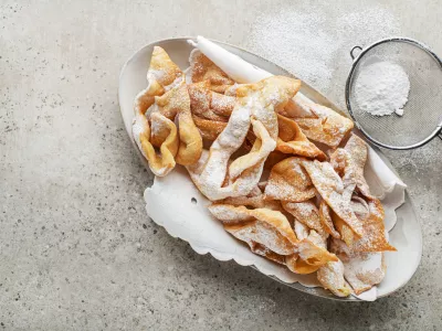 Traditional sweet crisp pastry - faworki or angel wings, deep-fried and sprinkled with powdered sugar / Foto: Dulezidar