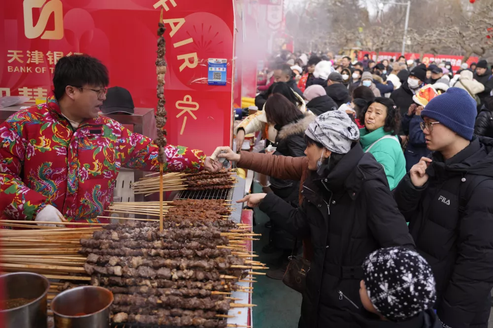 People buy food during the Longtan Park Temple Fair on the second day of Lunar New Year in Beijing on Thursday, Jan. 30, 2025. (AP Photo/Aaron Favila) / Foto: Aaron Favila