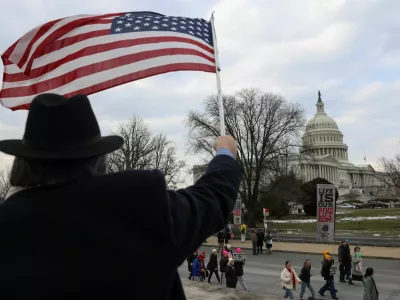 A person waves a U.S. flag as anti-abortion demonstrators walk past the U.S. Capitol during the annual March for Life rally, in Washington, U.S., January 24, 2025. REUTERS/Evelyn Hockstein