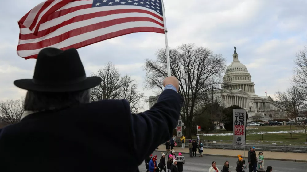 A person waves a U.S. flag as anti-abortion demonstrators walk past the U.S. Capitol during the annual March for Life rally, in Washington, U.S., January 24, 2025. REUTERS/Evelyn Hockstein