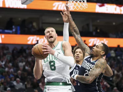 Jan 25, 2025; Dallas, Texas, USA; Boston Celtics center Kristaps Porzingis (8) drives to the basket as Dallas Mavericks forward P.J. Washington (25) defends during the second half at American Airlines Center. Mandatory Credit: Kevin Jairaj-Imagn Images