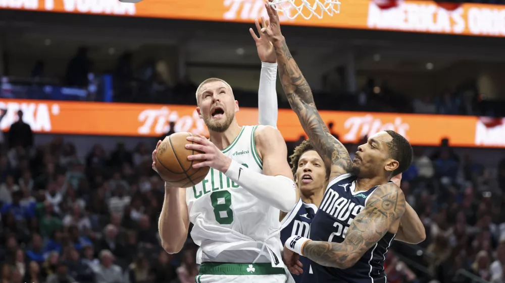 Jan 25, 2025; Dallas, Texas, USA; Boston Celtics center Kristaps Porzingis (8) drives to the basket as Dallas Mavericks forward P.J. Washington (25) defends during the second half at American Airlines Center. Mandatory Credit: Kevin Jairaj-Imagn Images