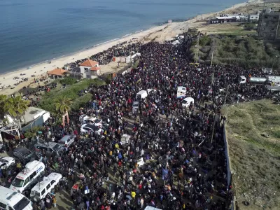 An aerial photograph taken by a drone shows displaced Palestinians gathering with their belongings near a roadblock on the al Rashid Street, as they wait to return to their homes in the northern part of the Gaza Strip, Sunday, Jan. 26, 2025, days after the ceasefire deal between Israel and Hamas came into effect. (AP Photo/Jehad Alshrafi)