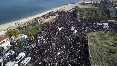 An aerial photograph taken by a drone shows displaced Palestinians gathering with their belongings near a roadblock on the al Rashid Street, as they wait to return to their homes in the northern part of the Gaza Strip, Sunday, Jan. 26, 2025, days after the ceasefire deal between Israel and Hamas came into effect. (AP Photo/Jehad Alshrafi)