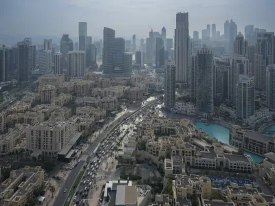 Vehicles ply at a slow pace through a street with Dubai's iconic skyline in the background, United Arab Emirates, on Dec. 31, 2024. (AP Photo/Altaf Qadri)