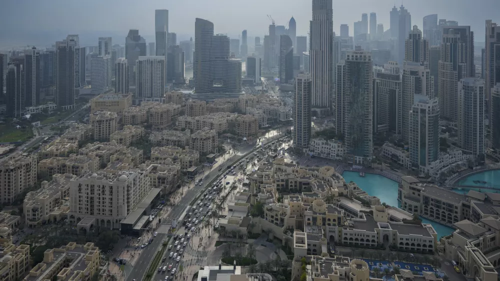 Vehicles ply at a slow pace through a street with Dubai's iconic skyline in the background, United Arab Emirates, on Dec. 31, 2024. (AP Photo/Altaf Qadri)