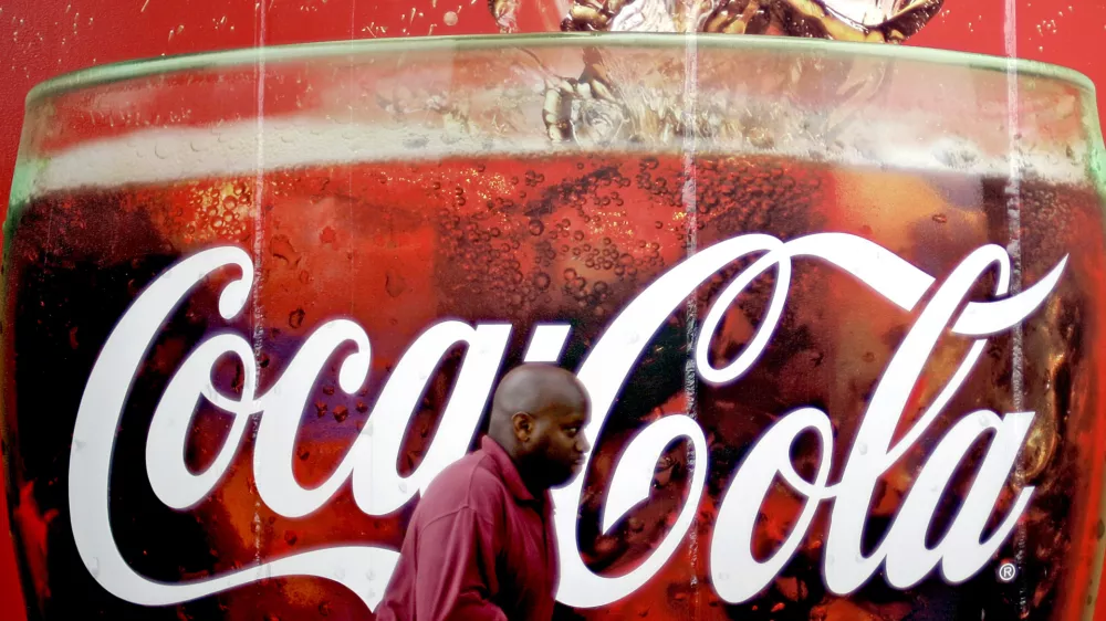 FILE- In this Monday, July 16, 2012, photo, a billboard for Coca Cola is seen outside a convenience store in Atlanta. The Coca-Cola Co. says its net income slipped in the second quarter from a year ago, as rising costs for ingredients offset its expansion overseas. The world's biggest beverage maker, which makes Minute Maid, Powerade and Dasani, says revenue growth was powered by higher prices in the U.S. and expansion in emerging markets such as India, where volume rose 20 percent.(AP Photo/David Goldman)