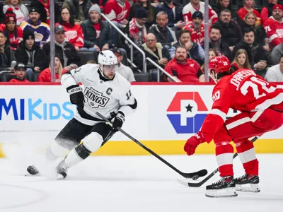 Jan 27, 2025; Detroit, Michigan, USA; Los Angeles Kings center Anze Kopitar (11) brings the puck up ice against Detroit Red Wings defenseman Albert Johansson (20) during the first period at Little Caesars Arena. Mandatory Credit: Tim Fuller-Imagn Images