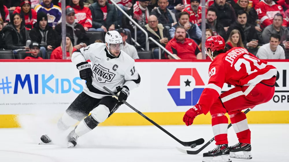 Jan 27, 2025; Detroit, Michigan, USA; Los Angeles Kings center Anze Kopitar (11) brings the puck up ice against Detroit Red Wings defenseman Albert Johansson (20) during the first period at Little Caesars Arena. Mandatory Credit: Tim Fuller-Imagn Images