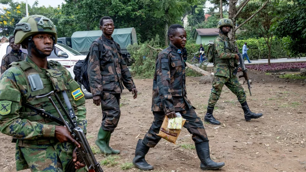 Rwandan security officers escort members of the Armed Forces of the Democratic Republic of the Congo (FARDC), who surrendered in Goma, eastern Democratic Republic of Congo following fighting between M23 rebels and the FARDC, in Gisenyi, Rwanda, January 27, 2025. REUTERS/Jean Bizimana