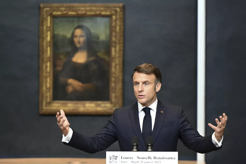 French President Emmanuel Macron gives a speech to announce a multi-year overhaul, long-term investments to modernize the Louvre museum, next to Leonardo da Vinci's painting of the Mona Lisa, at the Louvre Museum, Tuesday, Jan. 28, 2025 in Paris. (Bertrand Guay, Pool via AP)