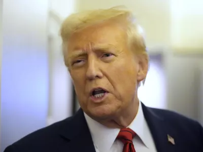 President Donald Trump speaks to reporters aboard Air Force One en route from Miami to Joint Base Andrews, Md., Monday, Jan. 27, 2025. (AP Photo/Mark Schiefelbein)