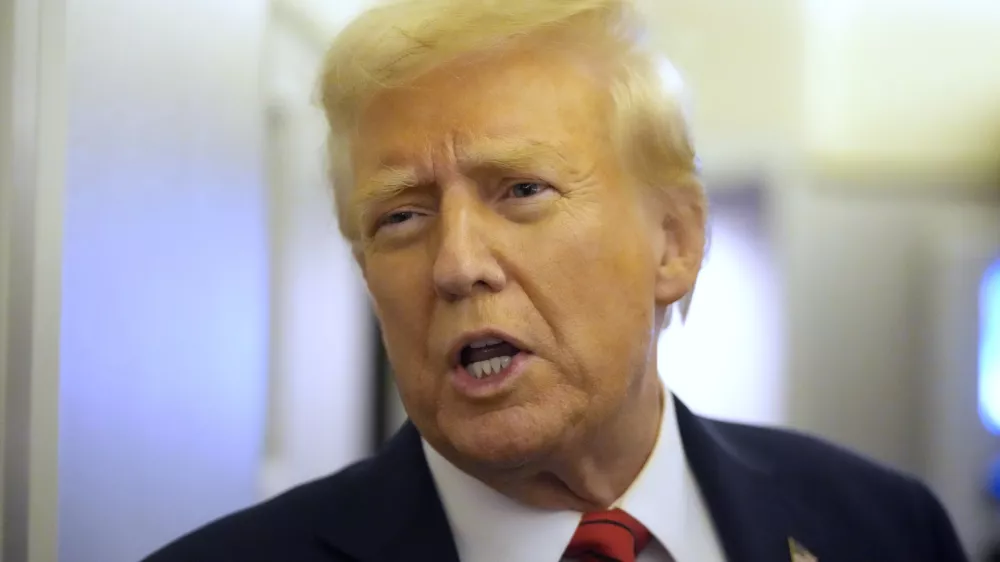 President Donald Trump speaks to reporters aboard Air Force One en route from Miami to Joint Base Andrews, Md., Monday, Jan. 27, 2025. (AP Photo/Mark Schiefelbein)