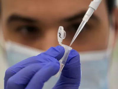 FILE - Research assistant Robert demonstrates how to prepare a sample for sequencing at the Wellcome Sanger Institute, Genome Campus, Hinxton, Cambridgeshire, England, Friday, on Jan. 7, 2022. After dropping most coronavirus restrictions in February 2022, Britain is now ending some COVID-19 testing and monitoring programs, a move some scientists fear will complicate efforts to track the virus and detect worrisome new variants. (AP Photo/Frank Augstein, File)