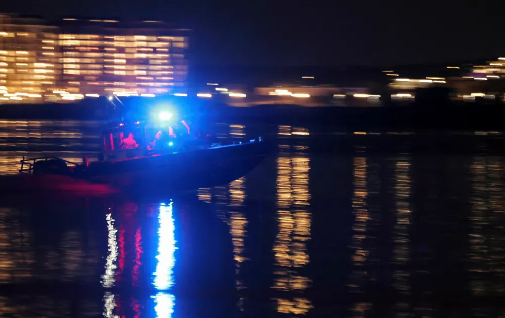 A search and rescue boat operates along the Potomac River near the site of the crash after American Eagle flight 5342 collided with a helicopter while approaching Ronald Reagan Washington National Airport and crashed in the Potomac River, outside Washington, U.S., January 29, 2025. REUTERS/Carlos Barria