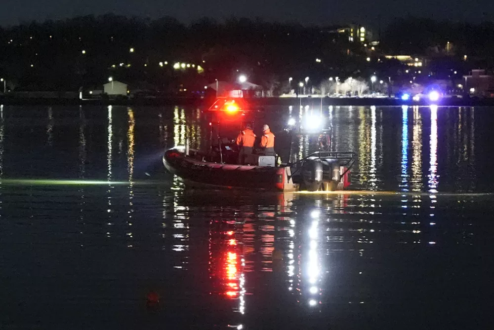 A boat works the scene near Ronald Reagan Washington National Airport, Thursday, Jan. 30, 2025, in Arlington, Va. (AP Photo/Alex Brandon)