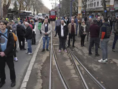 People stopping traffic, stand in silence during ongoing protests that erupted after a concrete canopy fell in the November and killed 15 people in Belgrade, Serbia, Wednesday, Jan. 29, 2025. (AP Photo/Darko Vojinovic)