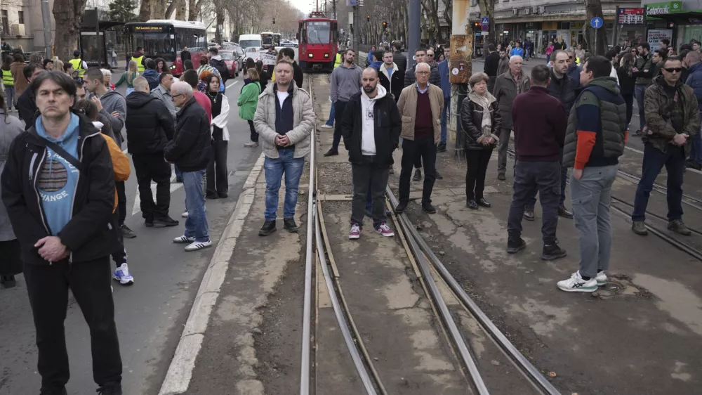 People stopping traffic, stand in silence during ongoing protests that erupted after a concrete canopy fell in the November and killed 15 people in Belgrade, Serbia, Wednesday, Jan. 29, 2025. (AP Photo/Darko Vojinovic)