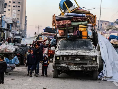 26 January 2025, Palestinian Territories, Gaza: Displaced Palestinians wait along Salah al-Din Road in Nuseirat, near the blocked Netzarim corridor, to cross to the northern part of the Gaza Strip. Many spent the night near the corridor, waiting for the road to reopen under the ceasefire agreement between Israel and Hamas. The return to their homes, many of which lie destroyed in the northern Gaza Strip, follows the handover of four Israeli female prisoners by Hamas in the central Gaza Strip. Photo: Abed Rahim Khatib/dpa