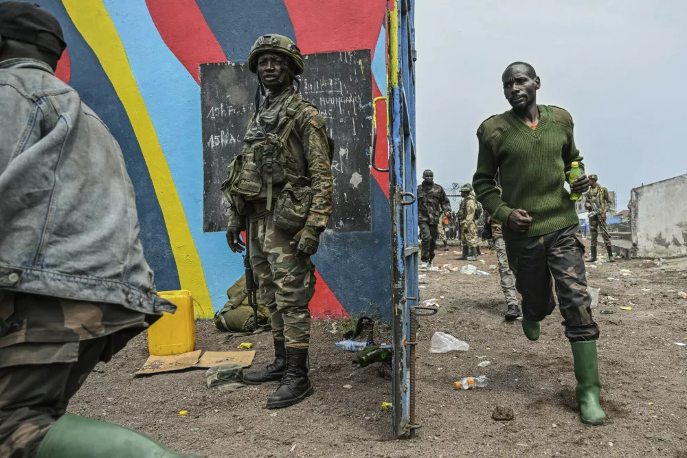 Government soldiers and police officers who surrendered to M23 rebels, center, run to board trucks to an undisclosed location in Goma, Democratic republic of the Congo, Thursday, Jan. 30, 2025. (AP Photo/Moses Sawasawa)