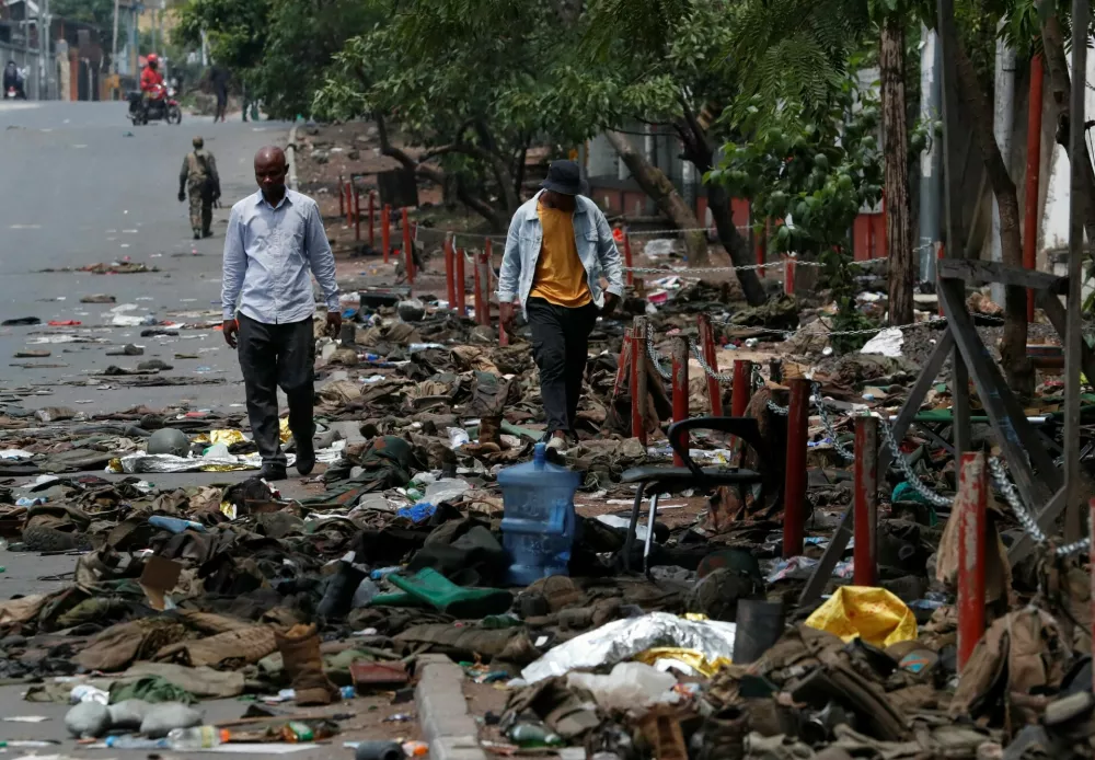 Civilians walk as they look at military uniforms and ammunition from the Armed Forces of the Democratic Republic of the Congo (FARDC) lying on the ground, amid clashes between them and the M23 rebels, in Goma, eastern Democratic Republic of the Congo, January 30, 2025. REUTERS/Stringer