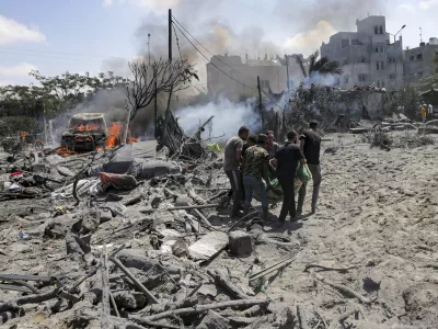 FILE - Palestinians evacuate a body from a site hit by an Israeli bombardment on Khan Younis, southern Gaza Strip, on July 13, 2024. Israel said it targeted Hamas' military commander Mohammed Deif in a massive strike Saturday. (AP Photo/Jehad Alshrafi, File)