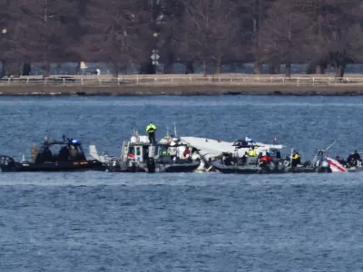 Emergency workers recover debris from the Potomac River in the aftermath of the collision of American Eagle flight 5342 and a Black Hawk helicopter, as seen from Virginia, U.S., January 30, 2025. REUTERS/Carlos Barria