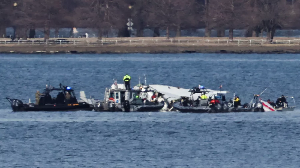 Emergency workers recover debris from the Potomac River in the aftermath of the collision of American Eagle flight 5342 and a Black Hawk helicopter, as seen from Virginia, U.S., January 30, 2025. REUTERS/Carlos Barria