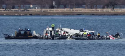 Emergency workers recover debris from the Potomac River in the aftermath of the collision of American Eagle flight 5342 and a Black Hawk helicopter, as seen from Virginia, U.S., January 30, 2025. REUTERS/Carlos Barria