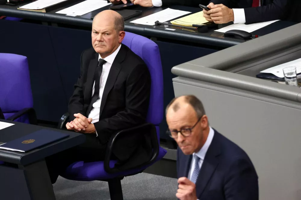 Christian Democratic Party (CDU) party leader Friedrich Merz speaks at the German lower house of parliament Bundestag, as German Chancellor Olaf Scholz looks on in the background, after the attacks in Magdeburg and Aschaffenburg, in Berlin, Germany, January 29, 2025. REUTERS/Liesa Johannssen