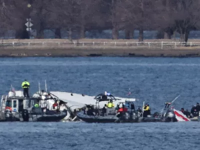 Emergency workers recover debris from the Potomac River in the aftermath of the collision of American Eagle flight 5342 and a Black Hawk helicopter, as seen from Virginia, U.S., January 30, 2025. REUTERS/Carlos Barria