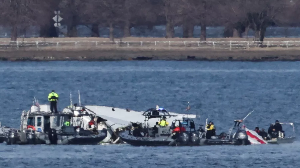 Emergency workers recover debris from the Potomac River in the aftermath of the collision of American Eagle flight 5342 and a Black Hawk helicopter, as seen from Virginia, U.S., January 30, 2025. REUTERS/Carlos Barria