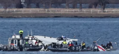 Emergency workers recover debris from the Potomac River in the aftermath of the collision of American Eagle flight 5342 and a Black Hawk helicopter, as seen from Virginia, U.S., January 30, 2025. REUTERS/Carlos Barria