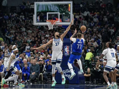 Dallas Mavericks guard Luka Doncic (77) attempts a shot over Minnesota Timberwolves center Rudy Gobert (27) in the first half of an NBA basketball game on Wednesday, Dec. 25, 2024, in Dallas. (AP Photo/Emil T. Lippe)