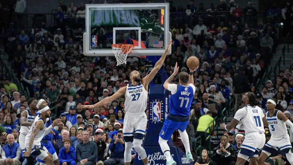 Dallas Mavericks guard Luka Doncic (77) attempts a shot over Minnesota Timberwolves center Rudy Gobert (27) in the first half of an NBA basketball game on Wednesday, Dec. 25, 2024, in Dallas. (AP Photo/Emil T. Lippe)