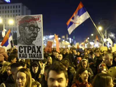 People gather during a protest over the collapse of a concrete canopy that killed 15 people more than two months ago, in Novi Sad, Serbia, Saturday, Feb. 1, 2025. The poster reads: "Not competent, fear as such".(AP Photo/Armin Durgut)