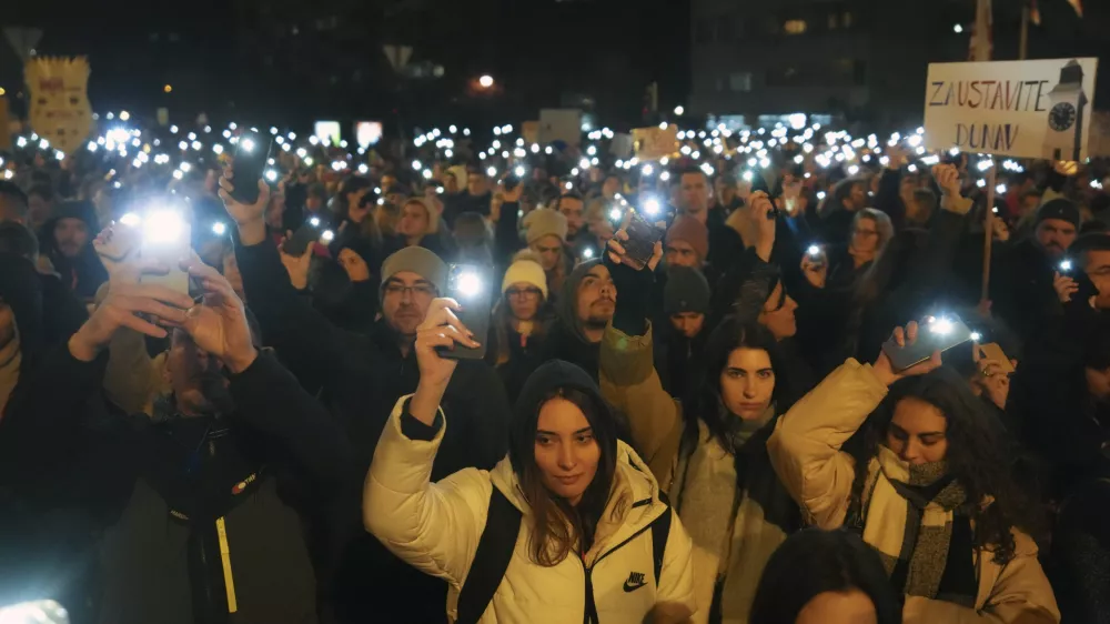 People hold up their mobile phone lights as tens of thousands gather for a protest over the collapse of a concrete canopy that killed 15 people more than two months ago, in Novi Sad, Serbia, Saturday, Feb. 1, 2025. (AP Photo/Darko Vojinovic)