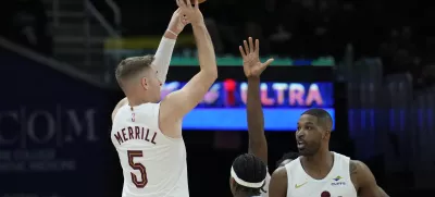 Cleveland Cavaliers guard Sam Merrill (5) looks to shoot next to Dallas Mavericks guard Brandon Williams, center, and Cavaliers' Tristan Thompson (13) in the second half of an NBA basketball game, Sunday, Feb. 2, 2025, in Cleveland. (AP Photo/Sue Ogrocki)