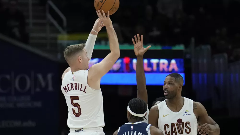 Cleveland Cavaliers guard Sam Merrill (5) looks to shoot next to Dallas Mavericks guard Brandon Williams, center, and Cavaliers' Tristan Thompson (13) in the second half of an NBA basketball game, Sunday, Feb. 2, 2025, in Cleveland. (AP Photo/Sue Ogrocki)