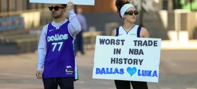 Ryan Safdarinia, left, and Lillian McCall hold signs reacting to the news that the Dallas Mavericks traded Luka Doncic to the Los Angeles Lakers outside the American Airlines Center, Sunday, Feb. 2, 2025, in Dallas. (Elias Valverde II/The Dallas Morning News via AP)